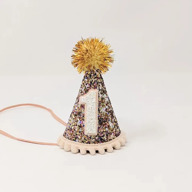 CONFETTI HAT, BLUSH TRIM AND GOLD TINSEL POM 1 CONFETTI HAT, BLUSH TRIM AND GOLD TINSEL POM